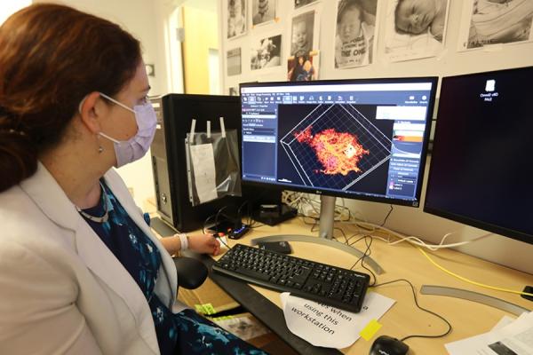 woman seated at a computer looking at an image