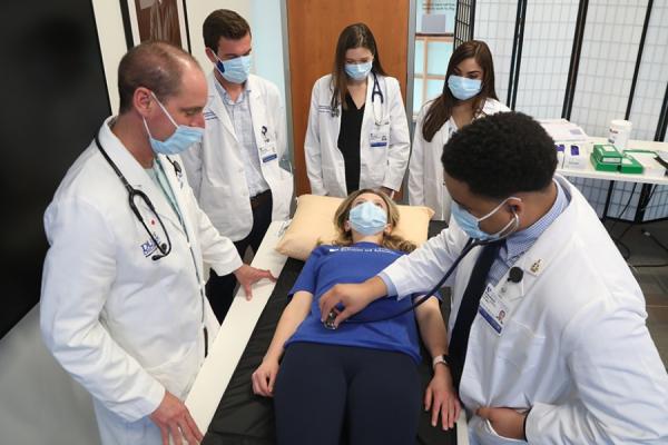 Duke medical students practice clinical skills on a pretend patient.
