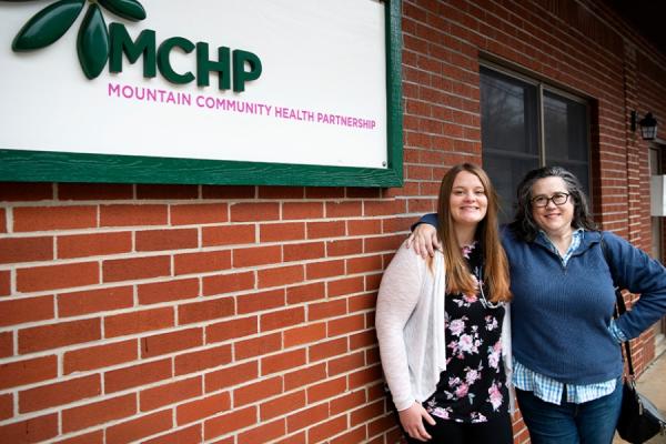 two women standing outside a health clinic