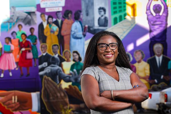 portrait of woman standing infront of mural