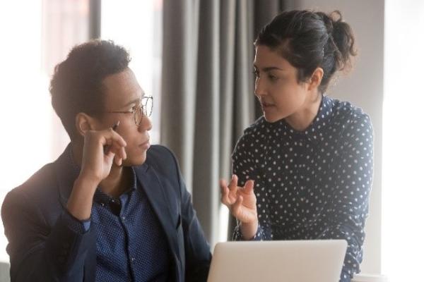 Man and woman talking to each other in front of computer