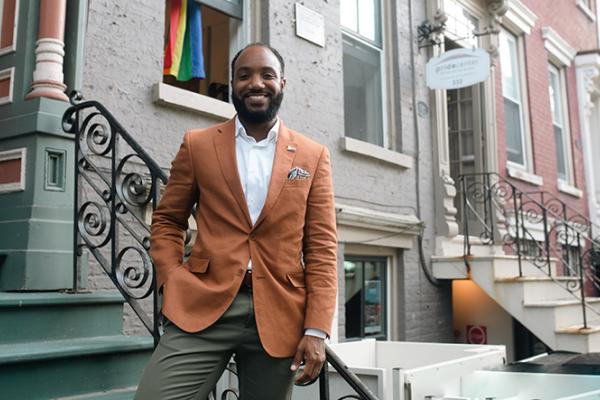 Man stands on steps outside NY apartment building