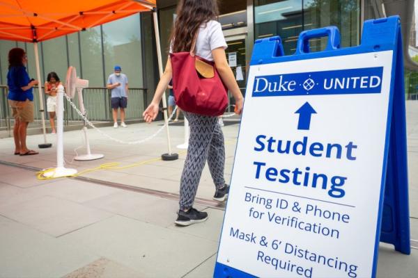 Student COVID testing information on a sign on Duke's campus