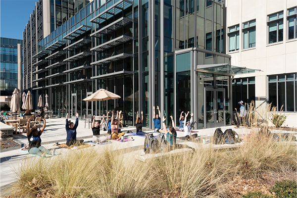 students doing yoga on a concrete patio