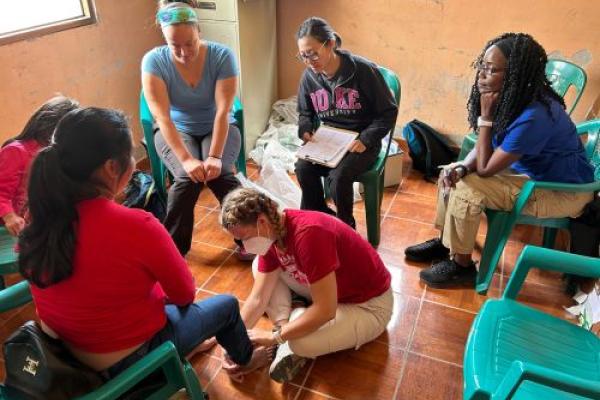 People in a circle working with a young girl. 