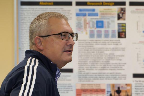 A shot of Steven George in front of a research poster 