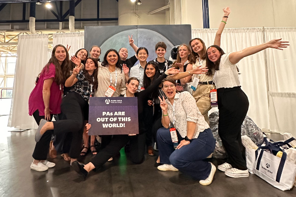 Students at AAPA conference holding sign that says "PAs are out of this world"