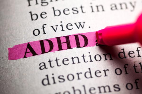 A pink highlighter highlights the word ADHD in a page of text.