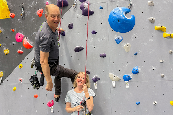 Joel and Caroline Graybeals on a rock climbing wall.