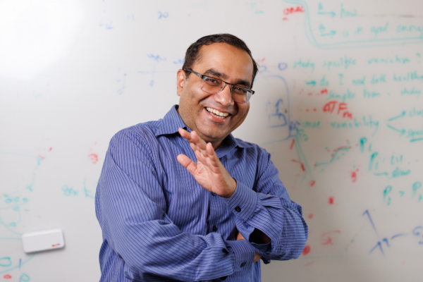 Rohit Singh, PhD, laughing in front of a whiteboard