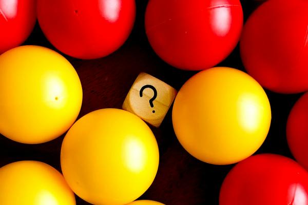 Red and yellow balls with square that has a question mark in middle