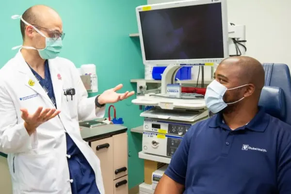 A provider in a white coat talks with a patient