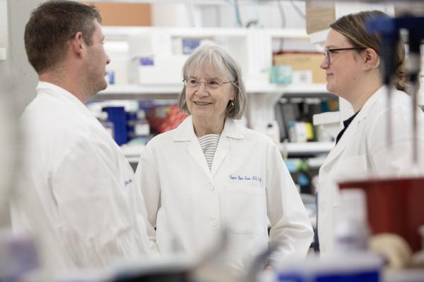Virginia Byers Kraus, MD, PhD, speaking with colleagues in the lab.