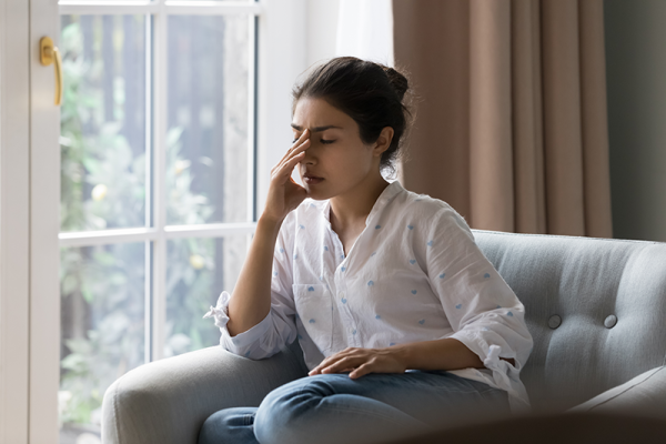 woman sitting on a sofa looking tired