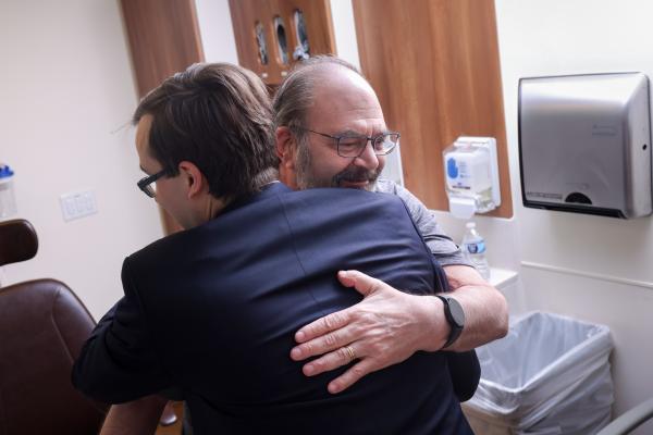 patient gratefully embracing his physician