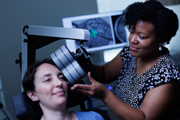 Tonisha Kearney-Ramos, PhD, demonstrating the repetitive transcranial magnetic stimulation (rTMS) procedure