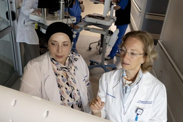 Ruba Sajdeya and Miriam Treggiari look at a computer monitor in a lab