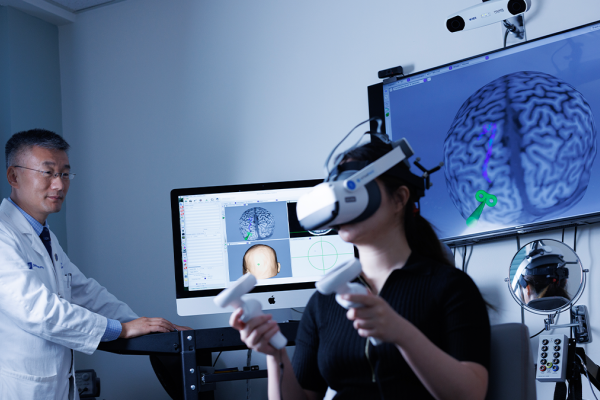 Dr. Feng in his lab with a patient wearing VR Glasses