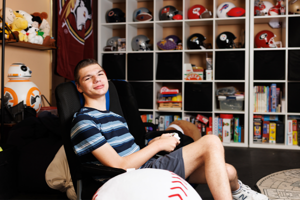 Matthew Wuchich, 18, poses for a photograph in his playroom while playing a baseball video game