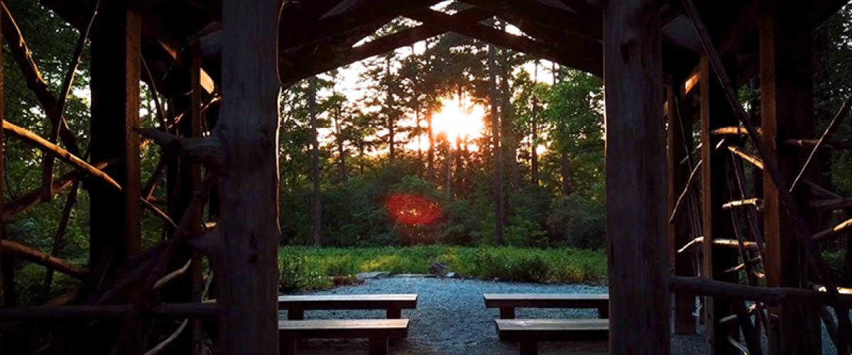 Sunset over meadow in Duke Gardens seen through pavillion