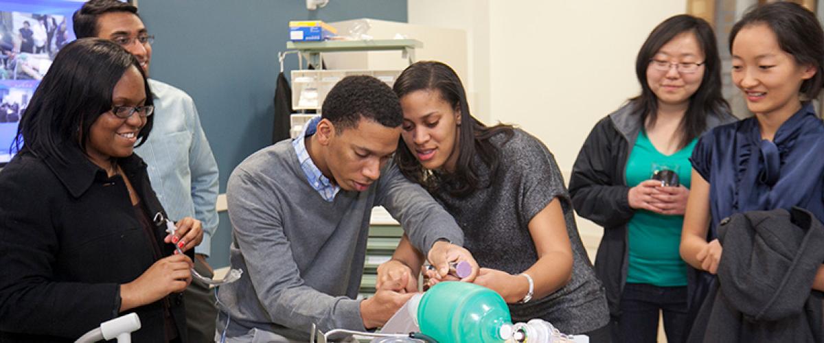 multiracial group of students demonstrating an intubation on a mannequin