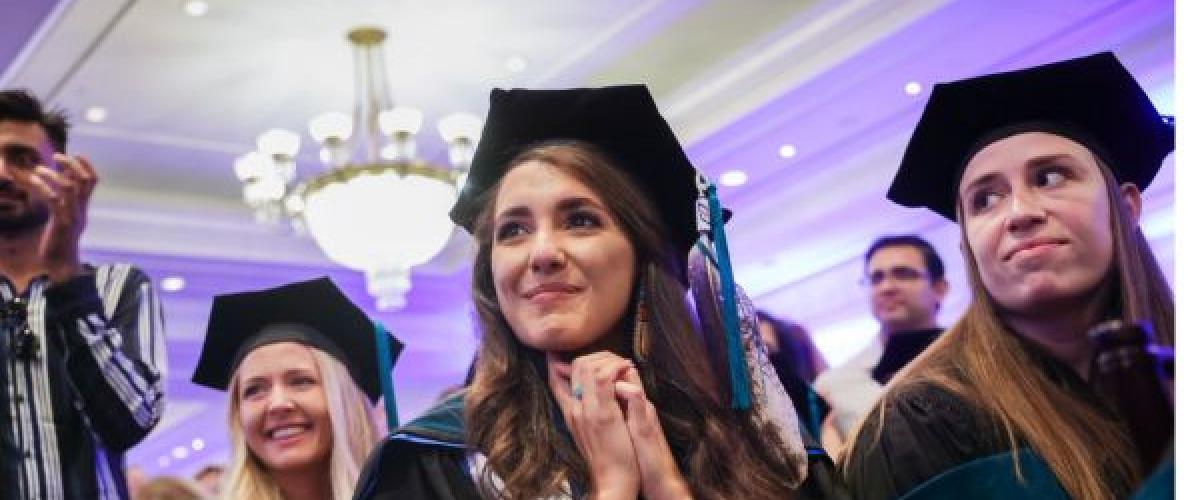 Three women in cap and gown at their graduation