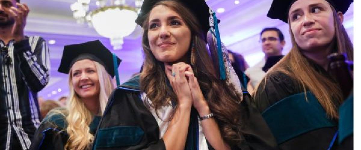 Three women in cap and gown at their graduation