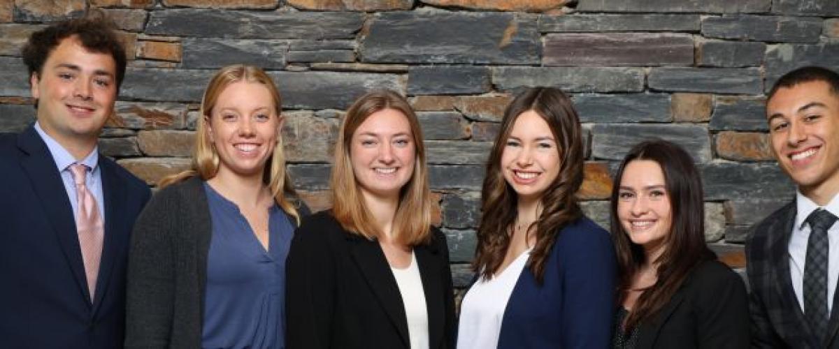 A group of students against a stone wall 