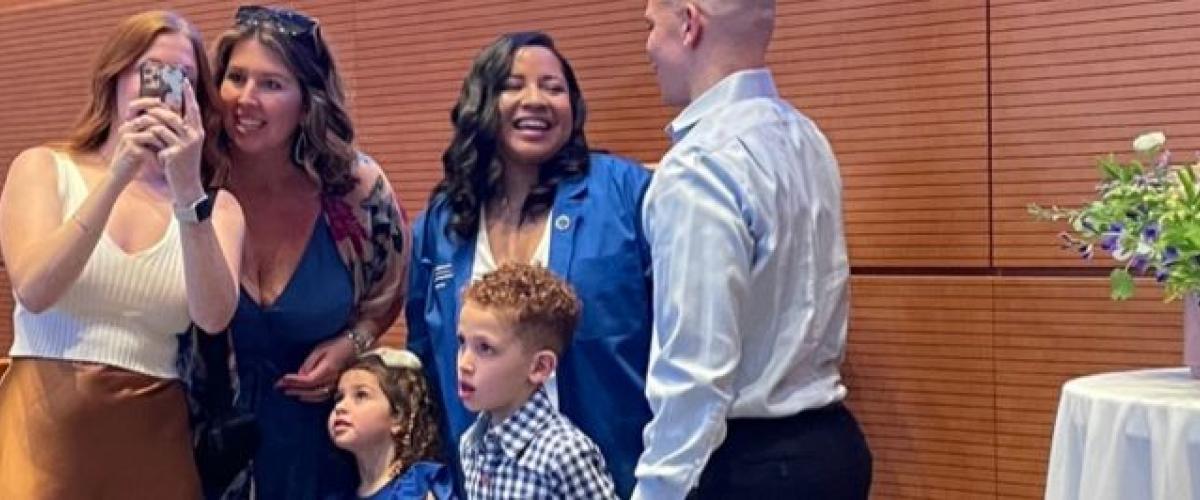 A family and friend group of six, together on a stage after OTD commissioning ceremony 