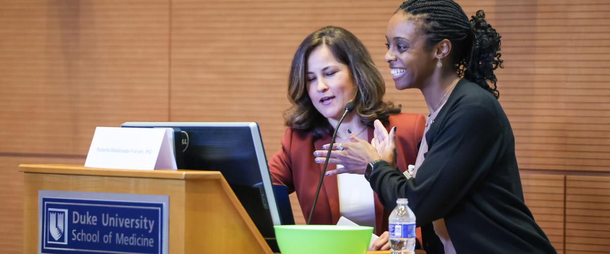 Two presenters at a podium.