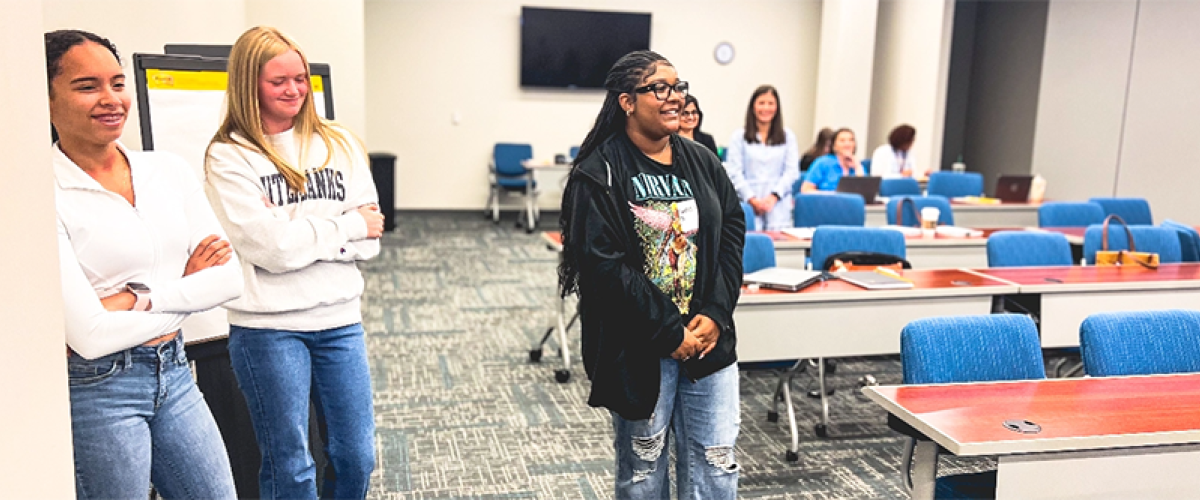 Three young women standing in a classroom