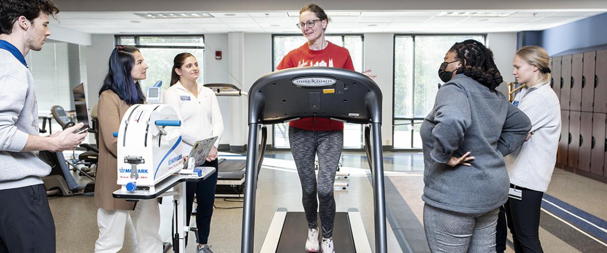 Duke DPT students working with a community volunteer on a treadmill