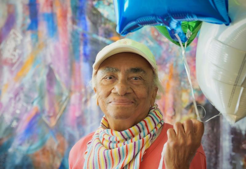 woman posing with balloon and colorful background 