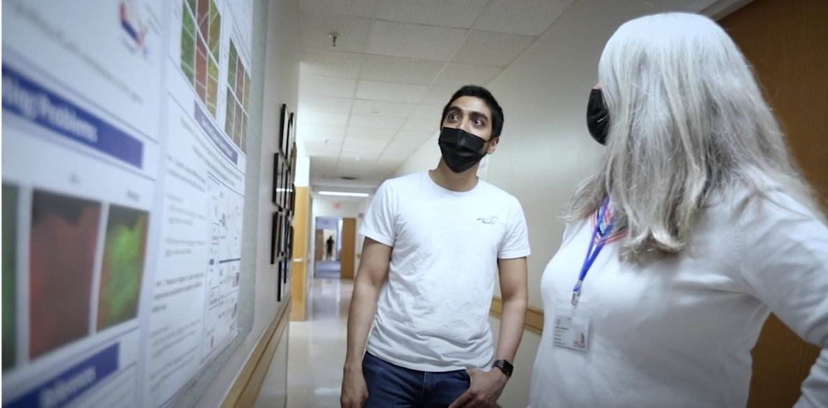 trainee and mentor standing in front of scientific poster