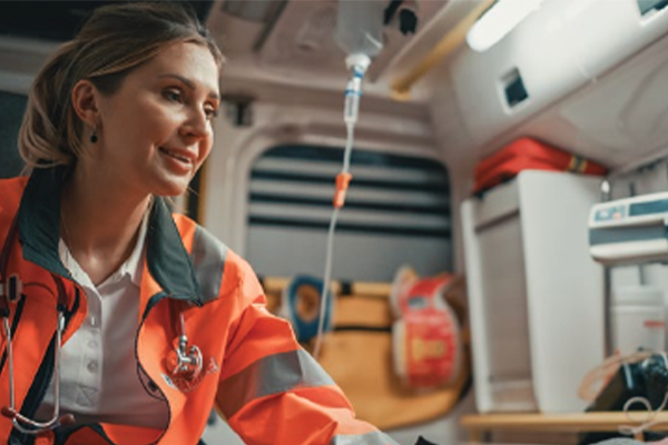 Woman First Responder in the back of an ambulance treating an unseen patient. 