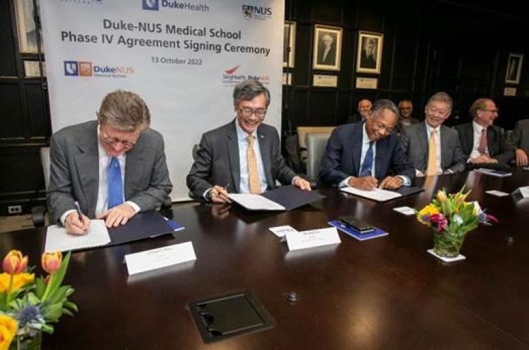 Leaders at Duke, Duke Health, and the National University of Singapore signing the agreement at a table