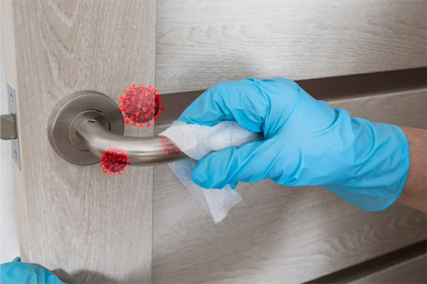 gloved hand wiping a door handle