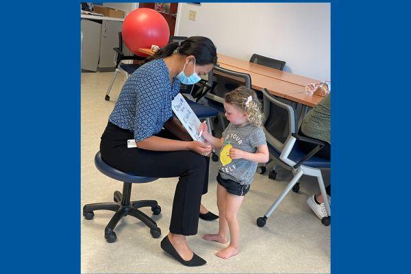 Student with a young girl and a dry erase board