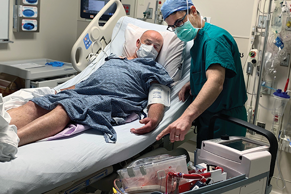 Jacob Schroder, MD, HS’01-’12, shows a patient the new heart he is about to receive.