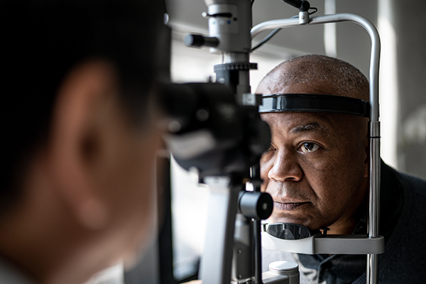 Older Black man undergoing an eye exam