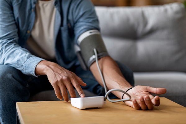 view of a person's arms as they perform an electronic BP test at home.