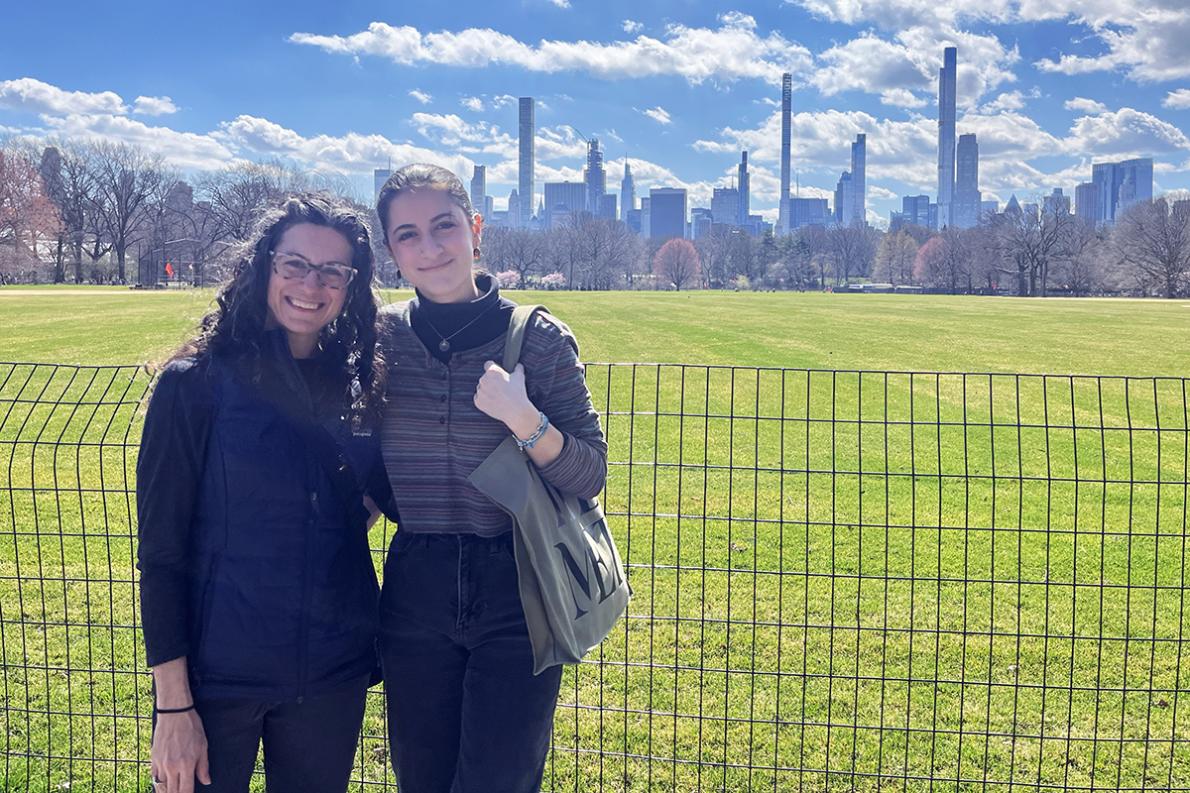 Raheleh and her daughter with a city skyline in the background