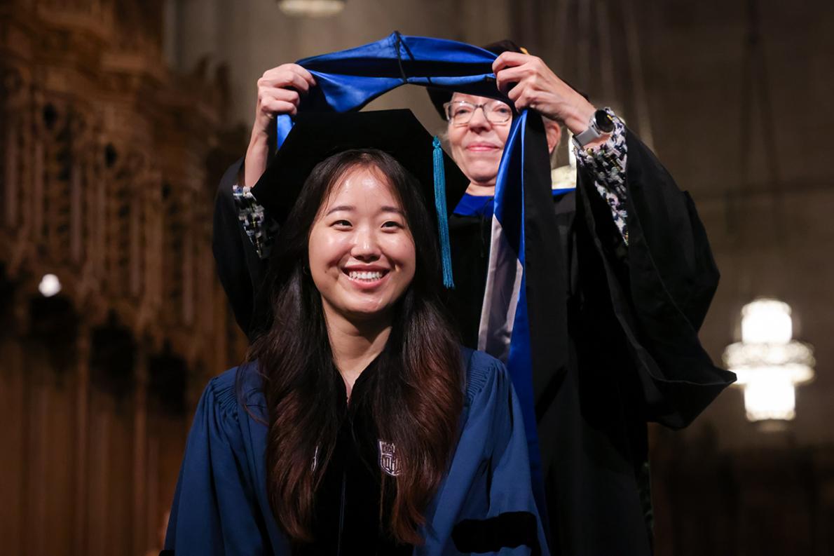 Jisun having her graduation shawl put on by the division chief