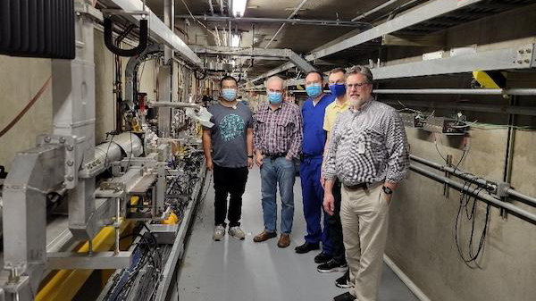 A group of researchers in a particle accelerator facility