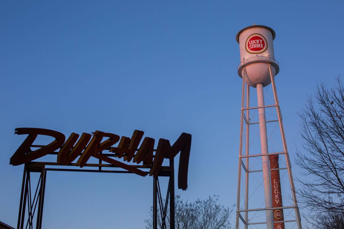 Photo of "Durham" sign with Lucky strike water tower in background