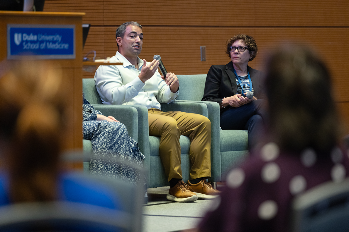 speaker sitting in a chair on a panel 