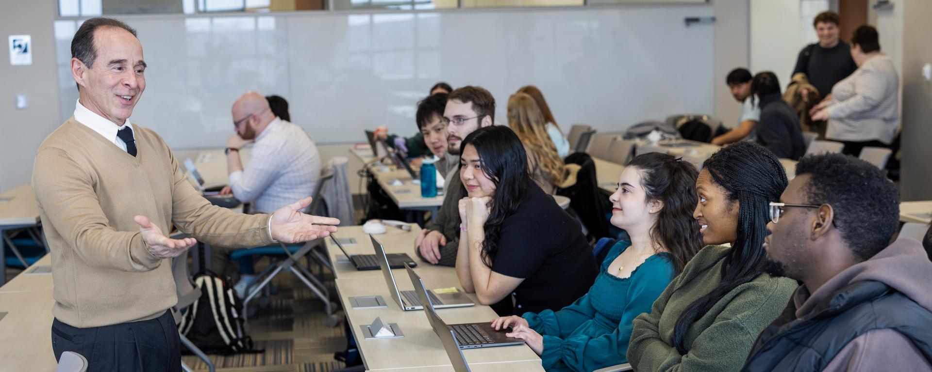 Lecturer talking to students in a classroom