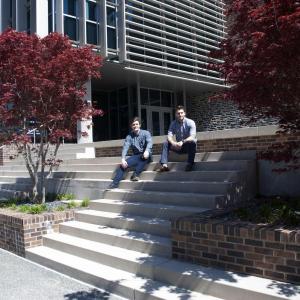 Two faculty sitting on the steps to the Trent Semans Center