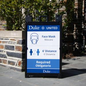 Duke sign that reads Duke United, face masks, six foot distance required