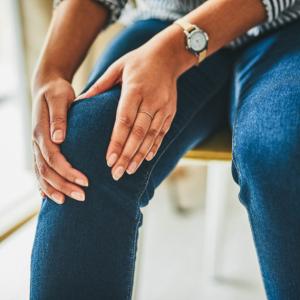 person holding on to knee cap as if it hurts